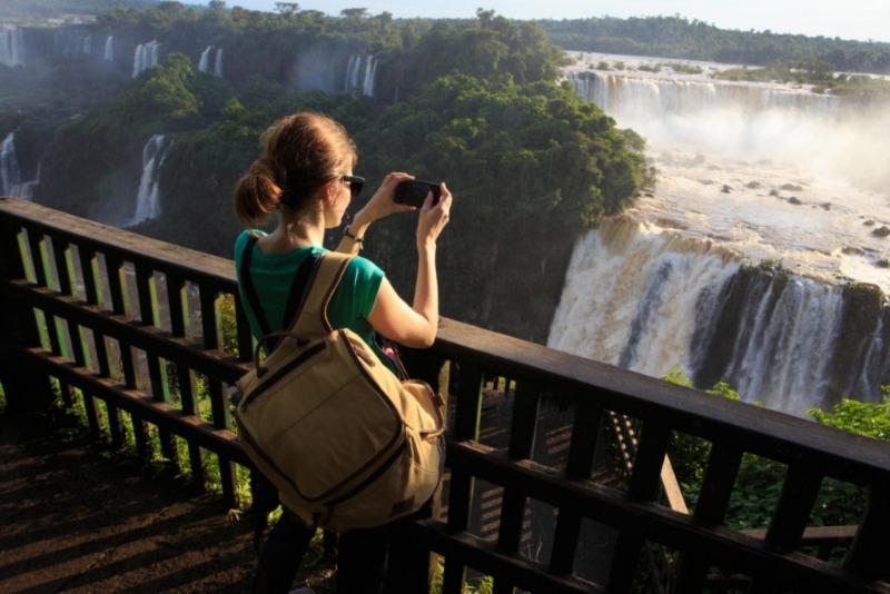 girl taking a photo of Iguassu waterfall with smartphone, Iguazu Falls girl taking a photo of Iguassu waterfall with smartphone, Iguazu Falls